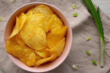 Crunch Green Onion Potato Chips in a Pink Bowl, top view. Flat lay, overhead, from above.
