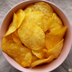 Crunch Green Onion Potato Chips in a Pink Bowl, top view. Flat lay, overhead, from above.