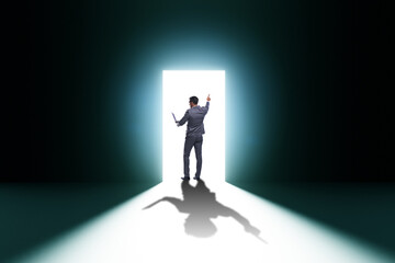 Obraz premium Businessman entering backlit door in escape concept