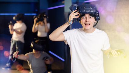Young man is exhilarated by unexpected turn of events in virtual game with friends 