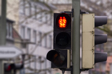 A pedestrian traffic light in support of gay female lesbian couple in Germany. Traffic light showing two women crossing holding their hands. Gay friendly concept.