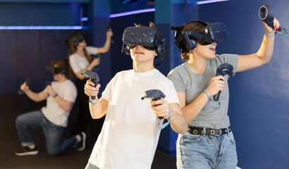 Portrait of young woman with virtual reality glasses standing in dark room