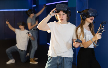 guy takes break while VR play with girl.excited guy took off his virtual reality helmet to take little rest. Pastime for urban youth