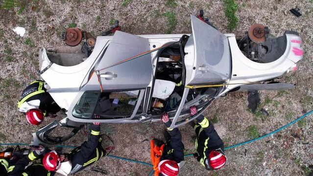 Aerial view Car Crash Traffic Accident. Firefighters Rescue Injured Trapped Victims. Firefighters work on an extrication using a hydraulic rescue tool. High quality 4k footage
