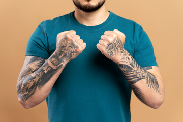 Cropped portrait of muscular asian man showing stylish tattoo on arms, wearing green casual t shirt...