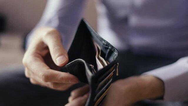 purse with cash in the hands of a man. little money. financial crisis, the economy and inflation. price increases, utility bills bankrupt business