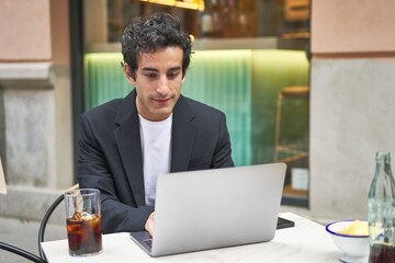 Young businessman hard at work with his laptop, focused on achieving his goals.