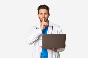 Young doctor man holding a laptop keeping a secret or asking for silence.