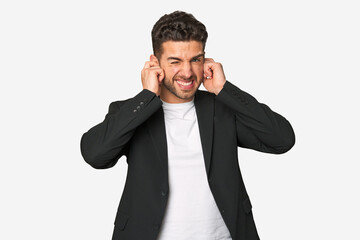 Young business man covering ears with hands.