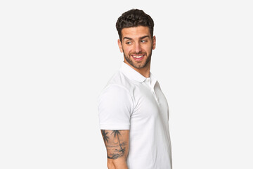 Young handsome man isolated looks aside smiling, cheerful and pleasant.