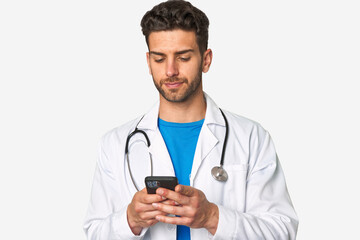 Busy young doctor sends a message with his phone