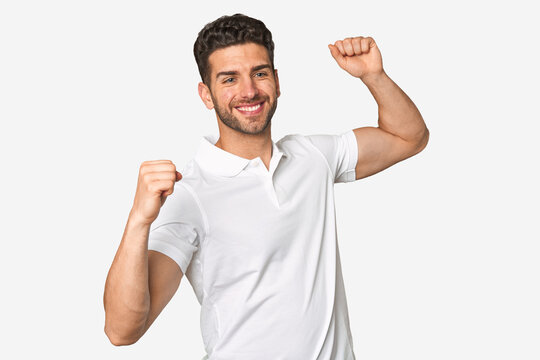 Young handsome man isolated celebrating a special day, jumps and raise arms with energy.