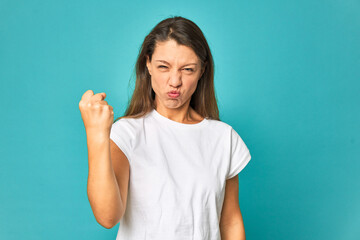 Fototapeta premium A young caucasian woman isolated showing fist to camera, aggressive facial expression.