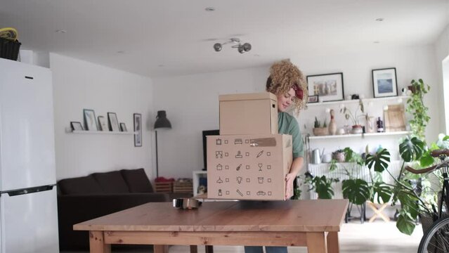 Young woman come into the room carrying delivery boxes