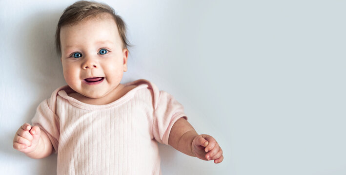 a large portrait of a newborn baby with blue eyes, the baby smiles and looks into the camera.photo for a cute baby banner