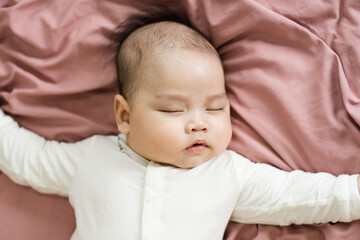 image of a newborn baby lying on a pink bed