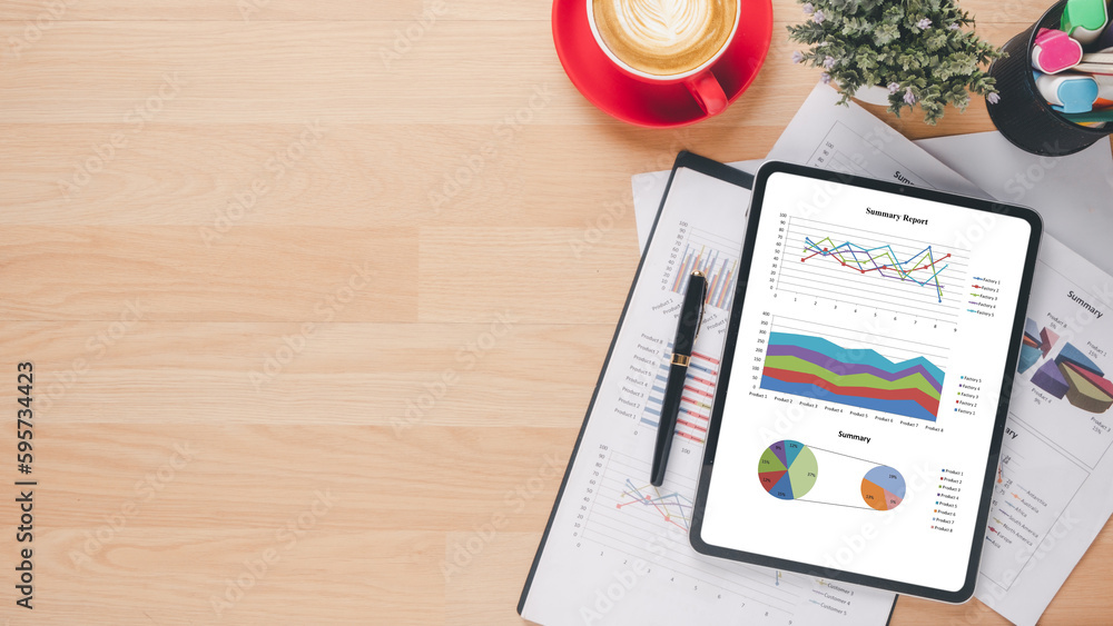 Poster tablet with charts and reports on office desk workplace. top view flat lay..