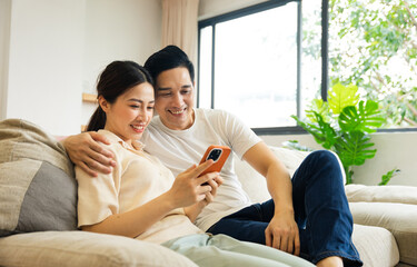 image of asian couple sitting on sofa at home
