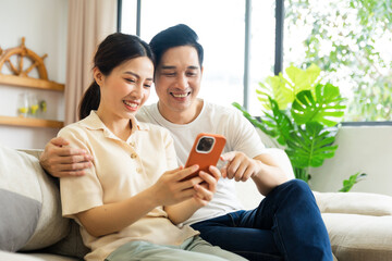 Obraz premium image of asian couple sitting on sofa at home
