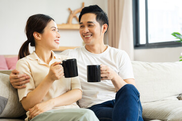 image of asian couple sitting on sofa at home