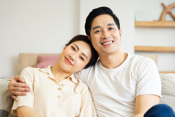 Obraz premium image of asian couple sitting on sofa at home