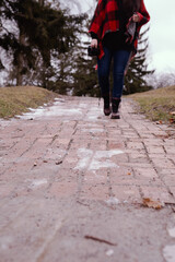 Fototapeta premium woman's legs walking in a pathway in the park during winter time