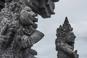 Traditional Balinese statues made of stone carvings in the form of gods, people or demons. Balinese sculpture in temple.