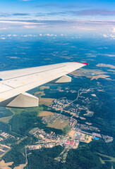 Obraz premium View from the airplane window at a beautiful cloudy sky and the airplane wing