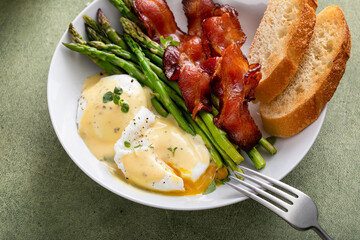 Healthy breakfast with poached eggs, bacon and asparagus