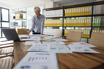 Businesswoman looks at papers in empty company office