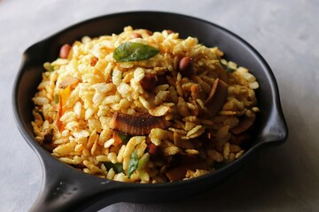 Thick Pohe Chiwda. Diwali special savory snack, made out of puffed rice, fried peanuts, curry leaves and some spices. Traditional Indian Diwali Snacks. with Copy Space.