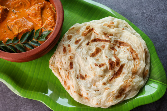 Fish curry with Kerala parathas porotta roti parotta barotta naan layered flatbread made from maida whole wheat flour. Eat with spicy Asian chicken beef egg curry gravy. breakfast dish. Indian food.