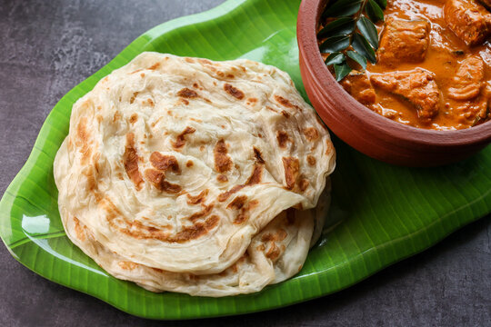 Fish curry with Kerala parathas porotta roti parotta barotta naan layered flatbread made from maida whole wheat flour. Eat with spicy Asian chicken beef egg curry gravy. breakfast dish. Indian food.