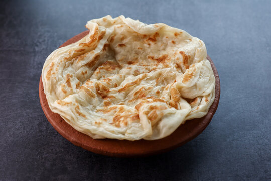 Kerala parathas porotta roti parotta barotta naan layered flatbread made from maida or whole wheat flour. Eat with spicy Asian chicken or beef or egg curry gravy. breakfast dish. Indian food.
