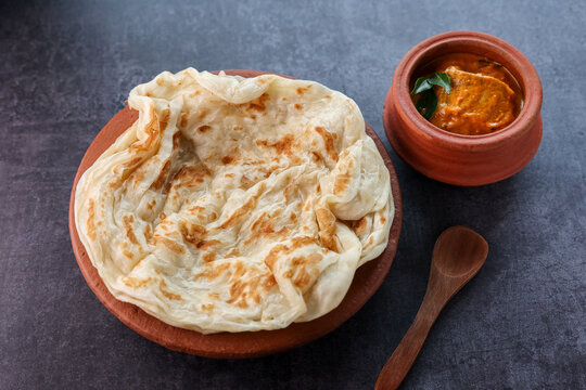Fish curry with Kerala parathas porotta roti parotta barotta naan layered flatbread made from maida whole wheat flour. Eat with spicy Asian chicken beef egg curry gravy. breakfast dish. Indian food.
