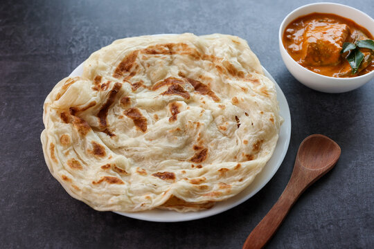 Fish curry with Kerala parathas porotta roti parotta barotta naan layered flatbread made from maida whole wheat flour. Eat with spicy Asian chicken beef egg curry gravy. breakfast dish. Indian food.