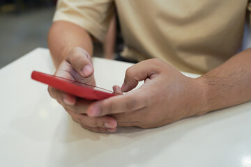 Relaxed young asian man using smart phone  spending time checking news social media.