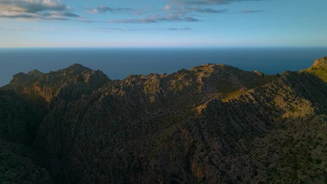 Palma de Mallorca Sa Calobra Port de Soller mountains. Green slopes and hills, blue seaside sky sunset horizon. Scenic Majorca Island mountain ridge peak nature aerial drone footage. Cinematic 4K UHD