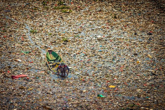 People collect trash that can be recycled and traded from the sea of garbage in the Citarum River, Bandung, Wes Java. Citarum River is the one of polluted river in Indonesia. 