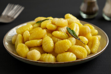 Homemade Easy Potato Gnocchi on a Plate on a black background, side view. Close-up.