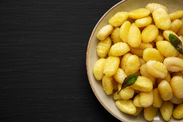 Homemade Easy Potato Gnocchi on a Plate on a black background, top view. Flat lay, overhead, from above. Copy space.