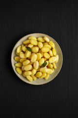 Homemade Easy Potato Gnocchi on a Plate on a black background, top view. Flat lay, overhead, from above.