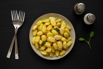 Homemade Easy Potato Gnocchi on a Plate on a black background, top view. Flat lay, overhead, from above.