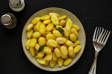 Homemade Easy Potato Gnocchi on a Plate on a black background, top view. Flat lay, overhead, from above.