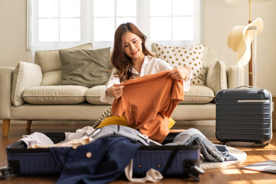 Portrait of backpacker beauty asian traveler woman packing prepare stuff and outfit clothes in suitcases travel bag luggage for summer, holiday, weekend, tourist, journey, vacation trip at home.travel