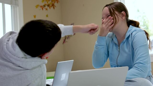 teenagers learn fooling around boy grabbed the girl by the nose pulls hand near the computer in the room friends fun spend time together 