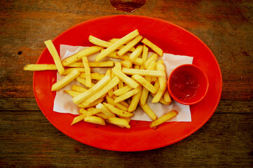 french fries with ketchup on plate on the table