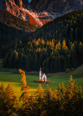 Val Di Funes, Dolomites, Italy - Summer sunset at the beautiful St. Johann Church (Chiesetta di San Giovanni in Ranui) at South Tyrol with the Italian Dolomites in warm golden colors at background