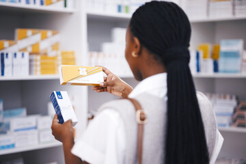 Pharmacy stock, woman and medicine check of a customer in a healthcare and wellness store. Medical, inventory and pharmaceutical label information checking of a black female person back by shop shelf