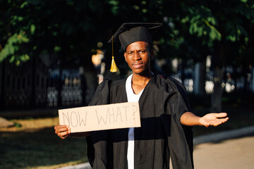Portrait of poor afro american guy holding cardboard poster and lending hand on street. Looking for...